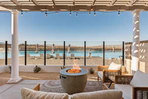 View of patio with a water view and an outdoor living space with a fire pit