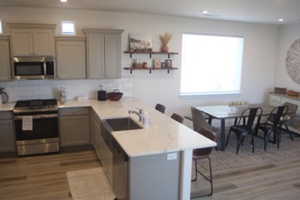 Kitchen featuring a kitchen bar, appliances with stainless steel finishes, and kitchen peninsula