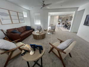 Carpeted living room with ceiling fan