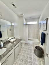 Bathroom featuring toilet, tile patterned flooring, walk in shower, and vanity