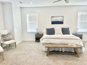 Bedroom featuring light carpet, multiple windows, and ceiling fan