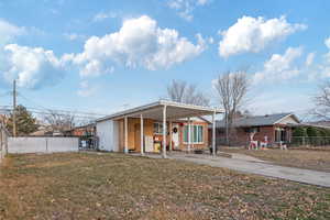 View of front facade with a front lawn and a carport