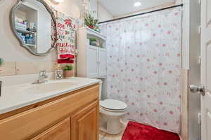 Bathroom with vanity, toilet, tile patterned floors, and a shower with curtain