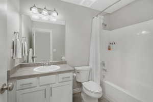 Full bathroom featuring vanity, toilet, and shower / tub combo with curtain