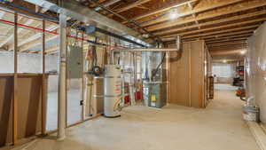 Basement featuring electric panel and secured water heater