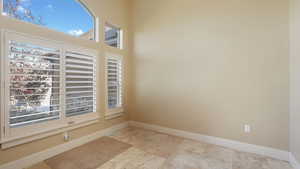 Unfurnished room featuring a towering ceiling