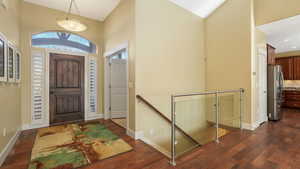 Entrance foyer featuring high vaulted ceiling and dark hardwood / wood-style flooring