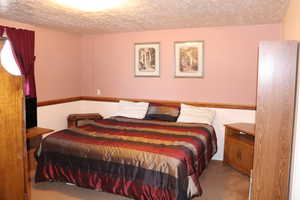 Bedroom with light carpet and a textured ceiling