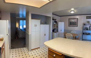 Kitchen with built in shelves and white fridge