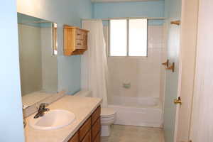 Full bathroom with vanity, toilet, and shower / bathtub combination with curtain