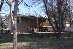 Back of property featuring a yard and a deck