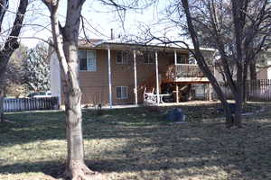 Rear view of property with a wooden deck and a yard