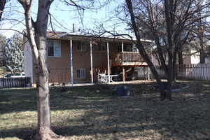 Rear view of property featuring a yard and a deck