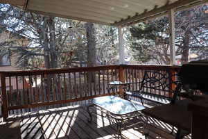 Snow covered deck featuring a grill