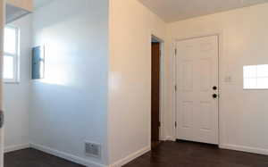 Foyer entrance with dark hardwood / wood-style floors