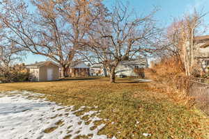 Yard layered in snow with a storage shed