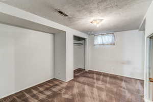 Unfurnished bedroom with a textured ceiling, carpet flooring, and a closet