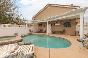 View of pool with an in ground hot tub, a patio area, and a pergola