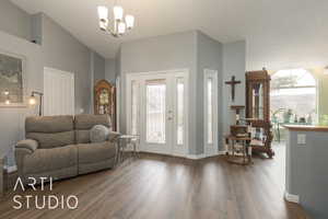 Entryway featuring an inviting chandelier, high vaulted ceiling, and dark hardwood / wood-style flooring