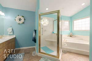 Bathroom with tile patterned floors, vanity, lofted ceiling, and plus walk in shower