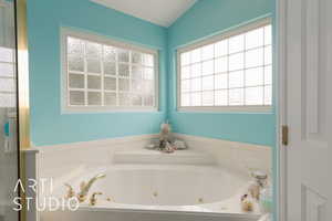 Bathroom with lofted ceiling and a bathing tub