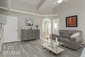 Living room featuring light hardwood / wood-style flooring, high vaulted ceiling, and ceiling fan