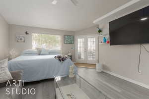 Bedroom with hardwood / wood-style flooring, access to exterior, and french doors