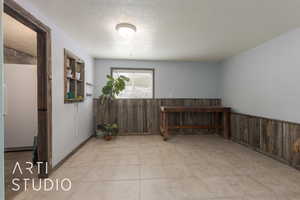 Spare room with wood walls and a textured ceiling