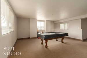 Rec room with carpet floors, a textured ceiling, and billiards