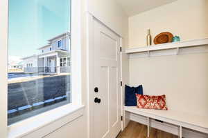 Mudroom with wood-type flooring and back door to townhouse.