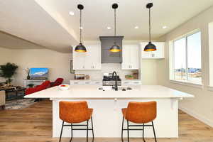 Kitchen featuring sink, a kitchen island with sink, and a breakfast bar area