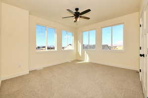 Carpeted empty room with ceiling fan