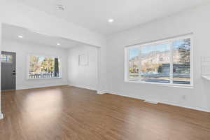 Unfurnished living room with hardwood / wood-style floors and plenty of natural light