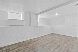 Spare room featuring wood-type flooring and a textured ceiling