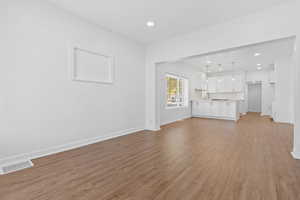 Unfurnished living room with sink and light hardwood / wood-style flooring