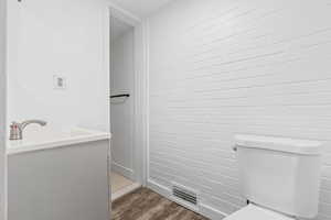 Bathroom featuring sink, hardwood / wood-style flooring, and toilet