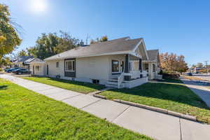 View of front facade featuring covered porch and a front lawn