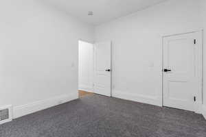 Unfurnished room with dark colored carpet