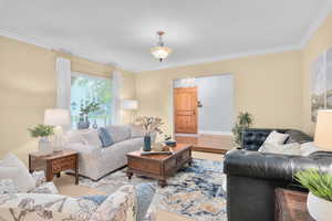 Living room with light hardwood / wood-style flooring and ornamental molding