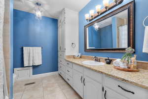 Bathroom featuring tile patterned flooring, vanity, and an inviting chandelier