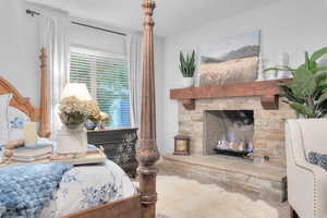 Bedroom featuring a stone fireplace