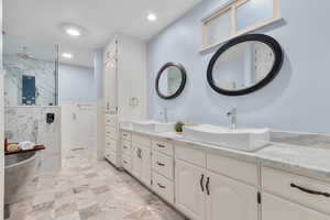 Bathroom with vanity and tiled shower