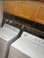 Laundry room featuring cabinets and washing machine and clothes dryer