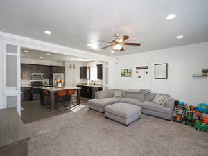 Carpeted living room with ceiling fan