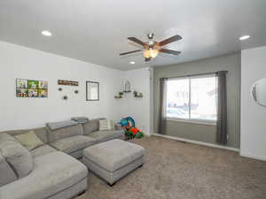 Carpeted living room with ceiling fan