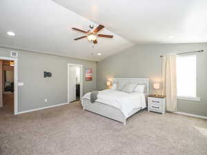 Carpeted bedroom featuring lofted ceiling and ceiling fan