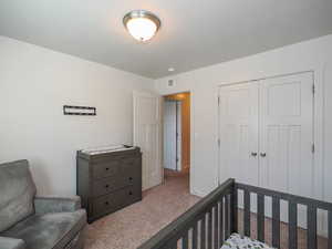 Bedroom with a closet and light colored carpet