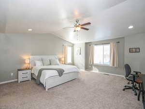 Carpeted bedroom with lofted ceiling and ceiling fan