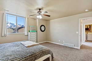 Bedroom with ceiling fan, washer and clothes dryer, a textured ceiling, and carpet floors