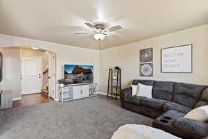 Carpeted living room with ceiling fan